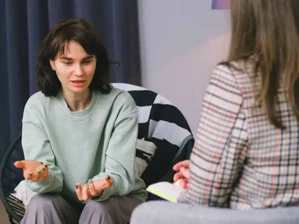 Młoda kobieta opowiada o swoich problemach, co może być początkiem skierowania do psychiatry.