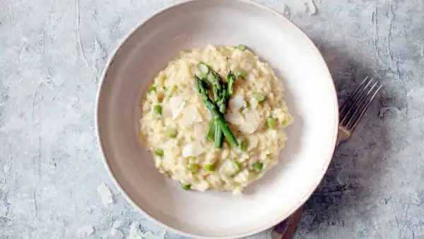 Cremiges Spargel-Erbsen-Risotto, garniert mit frischem Spargel und Parmesan. Ein köstliches Beispiel, was ist risotto.