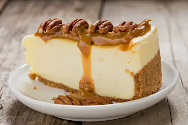 Deliciosa tarta de queso con dulce de leche y nueces pecanas, un postre irresistible.