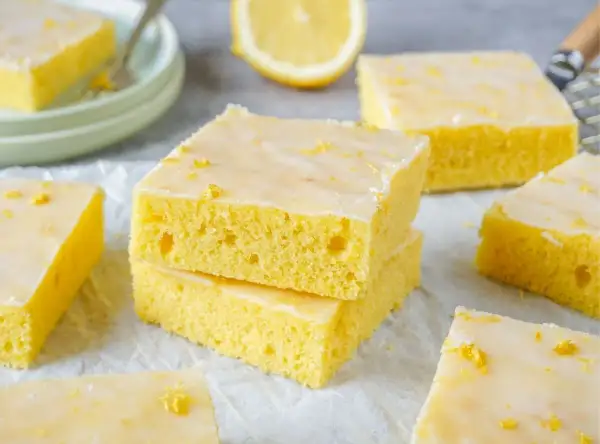 Saftiger zitronenkuchen blech, mit Zuckerguss und Zitronenschale bestreut, bereit zum Genießen.