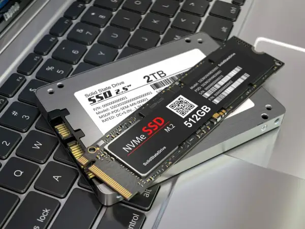 Dwa dyski SSD: 2.5-calowy 2TB i smukły M.2 512GB, leżą na klawiaturze laptopa. To nowoczesne rozwiązania, które pokazują, co to SSD.