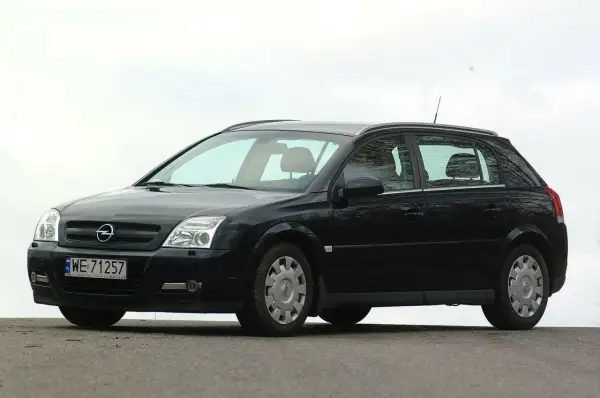 Czarny Opel Signum z czystymi żarówkami reflektorów, zaparkowany na zewnątrz.