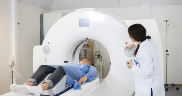 Pacjentka leży na stole tomografu komputerowego, a lekarka przygotowuje badanie. Dowiedz się, ile trwa tomografia komputerowa.
