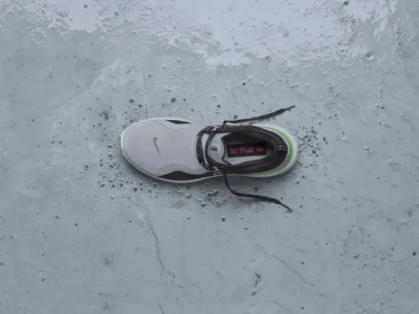 Scarpa da running Nike grigia, bagnata e sporca, pronta per essere messa in asciugatrice per un rapido recupero.