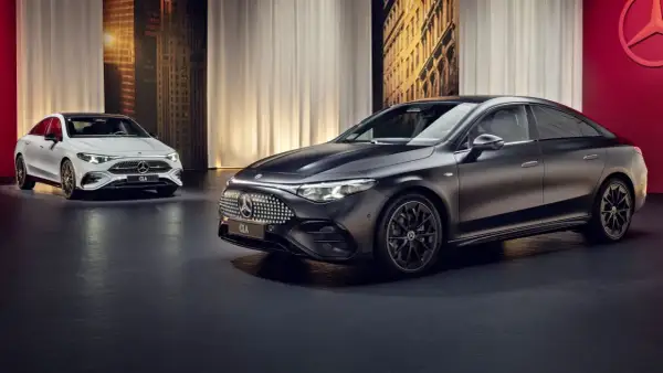 Elegancki, nowy Mercedes CLA w kolorze czarnym i białym prezentuje się na tle miejskiej panoramy.