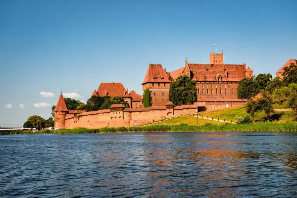 Potężny zamek w Malborku, jeden z najwspanialszych zabytków w Polsce, góruje nad rzeką Nogat.
