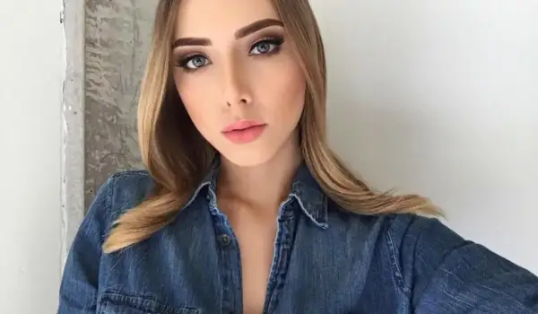 Młoda kobieta w dżinsowej koszuli, z makijażem i blond włosami, przypomina córkę Eminema.