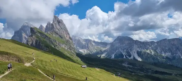 Sentiero panoramico tra prati verdi e vette maestose, ideale per escursioni in Alto Adige.