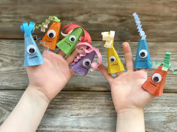 Kolorowe zabawki z recyklingu dla dzieci, wykonane z wytłoczek po jajkach, ozdabiają palce.