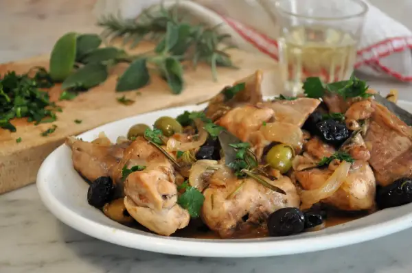 Piatto di coniglio alla cacciatora in bianco, con olive, cipolle e rosmarino. Un classico della cucina italiana.