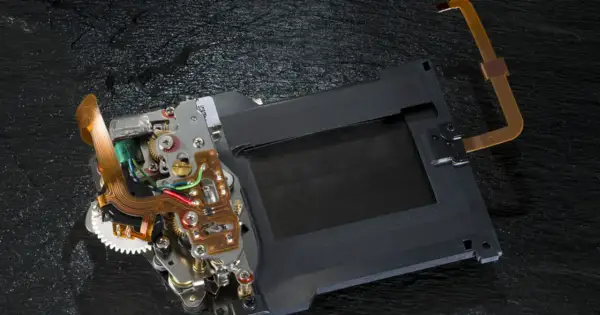 Mechanizm migawki szczelinowej aparatu z taśmami flex i elementami elektronicznymi.