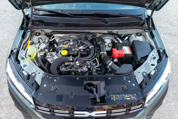 Vista del motor de un Dacia Sandero Stepway. Se aprecian componentes como la batería, el depósito de refrigerante y el sistema de admisión de aire.