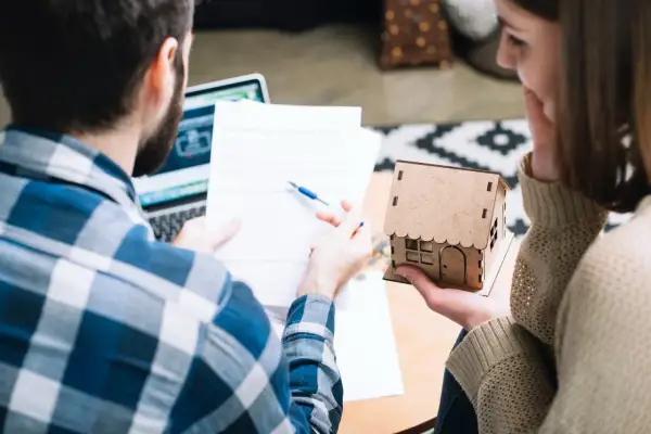 Pareja revisa documentos, planeando el futuro de su hogar, cuando un contrato de alquiler se convierte en indefinido.