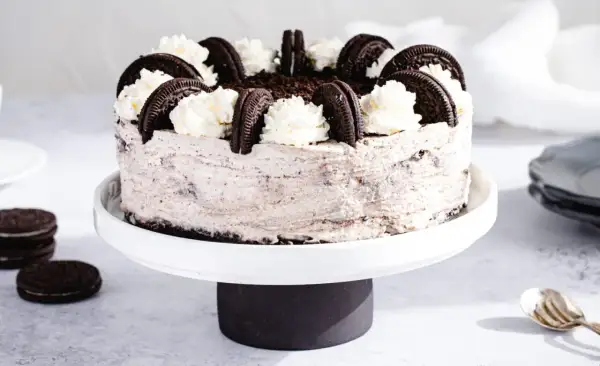 Wyjątkowe ciasto Oreo, udekorowane bitą śmietaną i ciasteczkami, kusi swoim wyglądem.