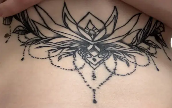 Ein detailliertes Blumen-Tattoo mit zarten Perlenketten. Leider sind einige Linien durch Tattoo Blowout unscharf geworden.