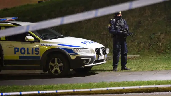 Polisbil och beväpnad polis, kanske Sandra Litzell, vid en avspärrning.