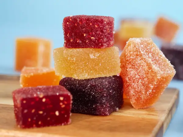 Délicieuses pâtes de fruits fait maison, colorées et enrobées de sucre, prêtes à être dégustées.