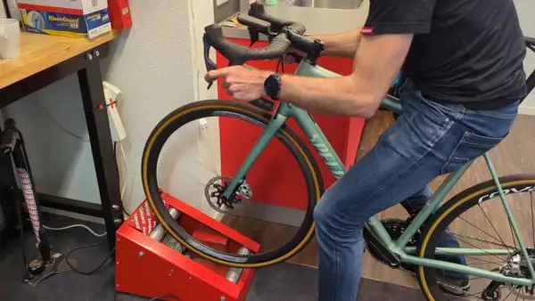 Man op een hometrainer, de schijfremmen inremmen door herhaaldelijk te remmen.
