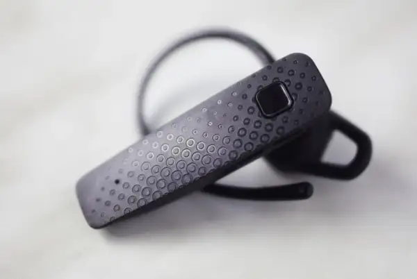 Czarna słuchawka Bluetooth z teksturą kółek. Dowiedz się, jak sparować słuchawki z telefonem.