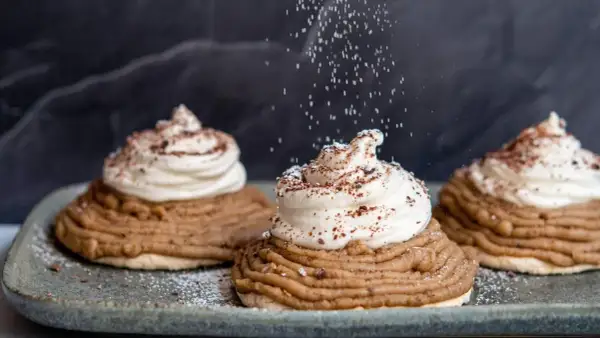 Deliciosas tartas Mont Blanc con crema batida y espolvoreadas con azúcar glas y cacao.