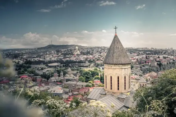Widok na Tbilisi z kościołem w pierwszym planie. Marzysz o podróży? Sprawdź, ile trwa lot do Gruzji!