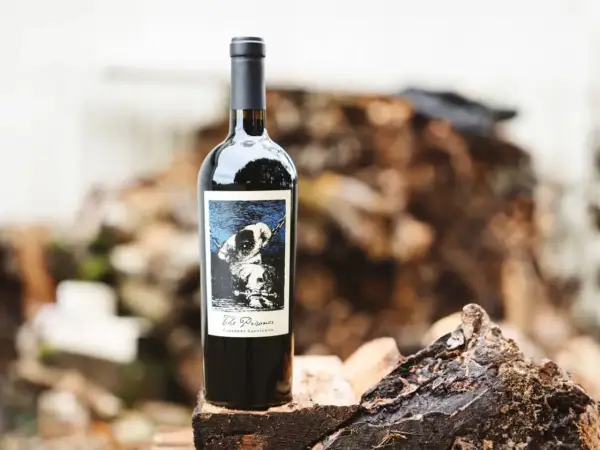 En flaska "The Prisoner" Cabernet Sauvignon står på en träbit. Etiketten visar en hund i kedjor, vilket ger en hint om hur detta vin kan kallas.
