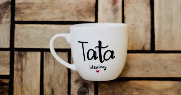 Biały kubek z napisem "Tata idealny" i serduszkiem. Świetny pomysł, jak zrobić prezent dla taty.