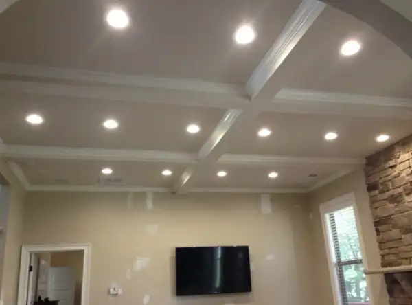 A coffered ceiling with recessed lighting, questioning if recessed lighting is out of style.