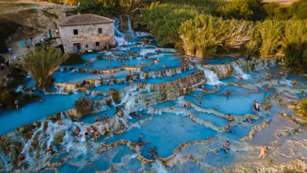 Cascate termali con gente che si rilassa. Per sapere come arrivare alle terme di Saturnia, guarda questa meraviglia naturale.