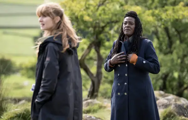 Två kvinnor i mörka rockar utomhus, en med blont hår, den andra med dreadlocks. Scen från engelska kriminalserier.