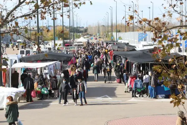 Gente paseando y comprando en un bullicioso mercadillo al aire libre cerca del auditorio de Zaragoza.