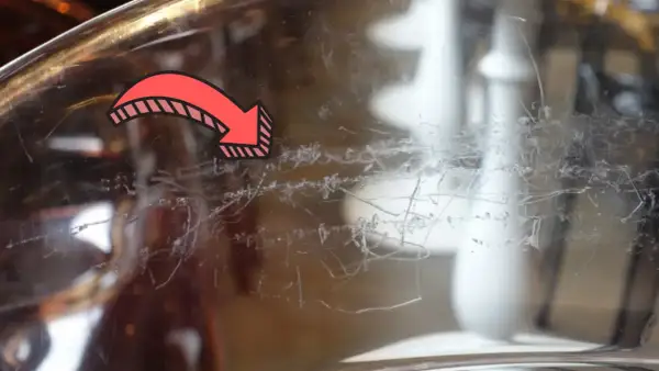 Flèche rouge indiquant des traces de peinture à enlever sur du verre.
