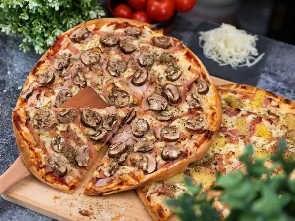 Två läckra pizzor, en med svamp och skinka, den andra med ananas. Perfekt för en mysig kväll, men tänk på libapizza kalorier!