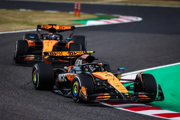 Dos coches de Fórmula 1 de McLaren, con el equipo de Andrea Stella, compiten en una curva.