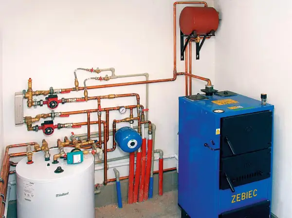 Instalacja grzewcza z kotłem, zasobnikiem i pompami obiegowymi. System zapewnia ogrzewanie podłogowe i grzejniki na jednym obiegu.