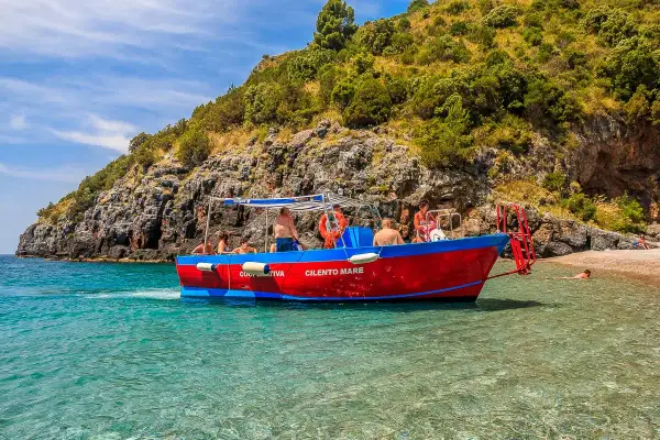 Gita in barca a Marina di Camerota, con gente che si gode il mare cristallino e la costa rocciosa. Perfetto per scoprire cosa fare a Marina di Camerota.