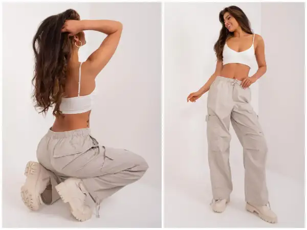 Modelka w beżowych bojówkach i białym topie. Idealne buty do kulotów? Grube trapery świetnie uzupełniają ten look.