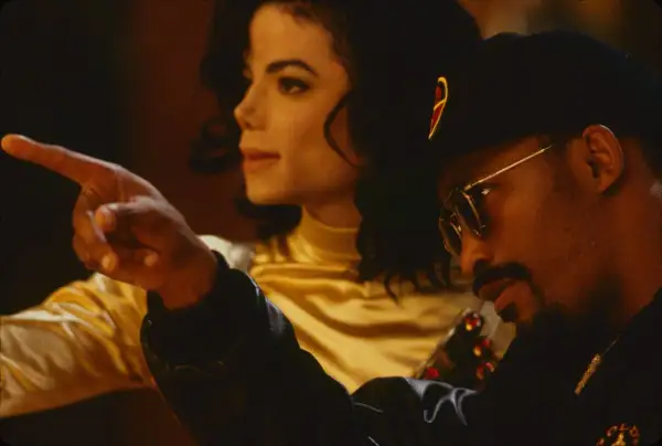 Teddy Riley points as Michael Jackson looks on, a moment captured during their creative collaboration.