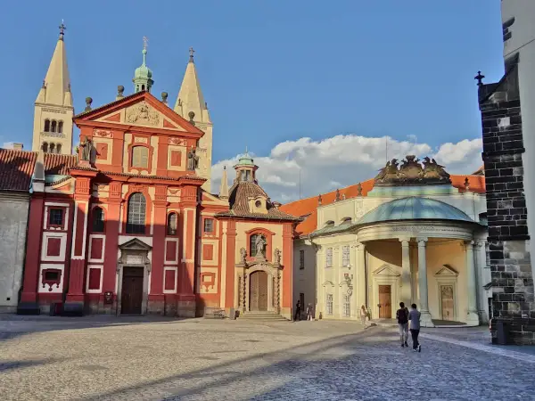Visite à Prague : la place pavée devant la basilique Saint-Georges et le monastère, avec des touristes se promenant sous un ciel bleu.