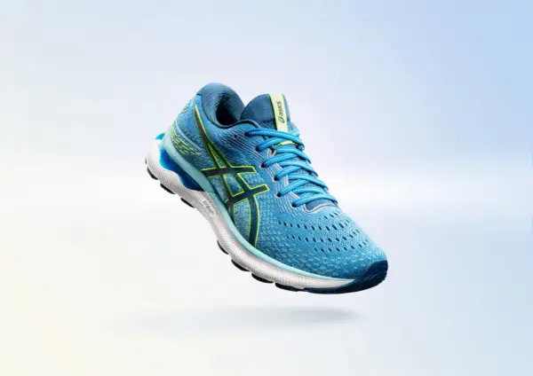 Scarpa da running Asics Gel Nimbus 24 uomo blu con dettagli gialli, in volo su sfondo sfumato.