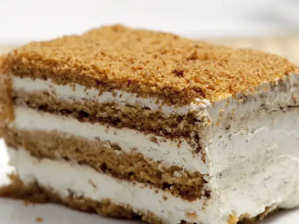 Tranche de gâteau à la crème et aux miettes de biscuit.