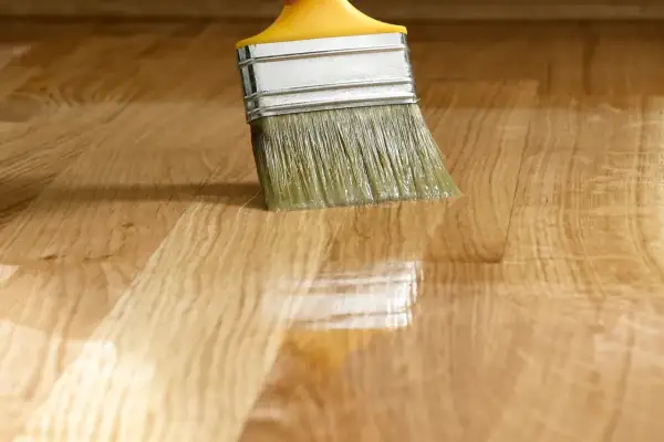 Pennello applica vernice su legno, creando una finitura satinato significato.