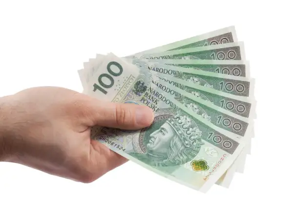 Dłoń trzyma wachlarz banknotów 100 zł. Może to być zapłata za zachowek lub po prostu wypłata pieniędzy.