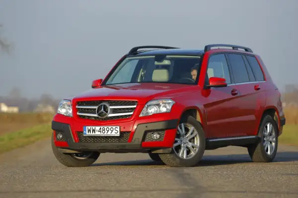 Czerwony Mercedes GLK na drodze. Poznaj jego kompaktowe wymiary i wszechstronność.