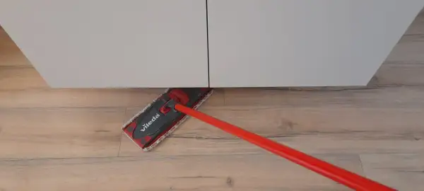 Mocio Vileda rosso pulisce il pavimento in legno, mostrando come smacchiare il legno con facilità.