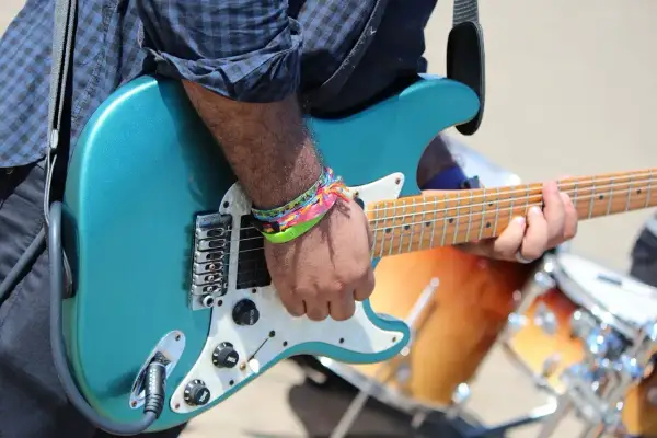 Ręka grającego na gitarze z kolorowymi bransoletkami, nie nie nie, to muzyka!