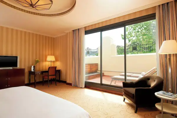 Habitación de lujo con terraza privada y tumbonas, ideal para relajarse tras un día en el spa Westin Valencia.