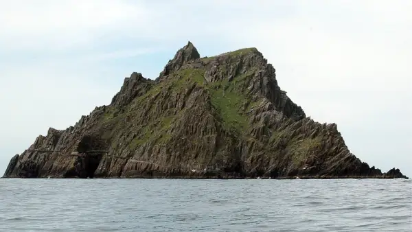 Skellig Michael, zielona, skalista wyspa na oceanie. Planując jak zorganizować logistykę trasy na wyspę Skellig Michael, pamiętaj o trudnym dostępie i zmiennej pogodzie.