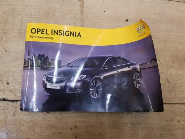 Okładka instrukcji obsługi Opel Insignia z widokiem na ciemny samochód na tle nocnego miasta.