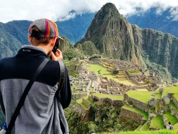 Turysta robi zdjęcie Machu Picchu. To idealne miejsce, by sprawdzić, kiedy najlepiej lecieć do Peru, by podziwiać te cuda.
